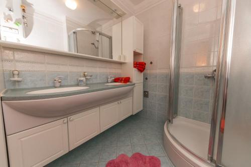 a bathroom with a sink and a shower and a tub at Apartment Arbanija 14825b in Trogir