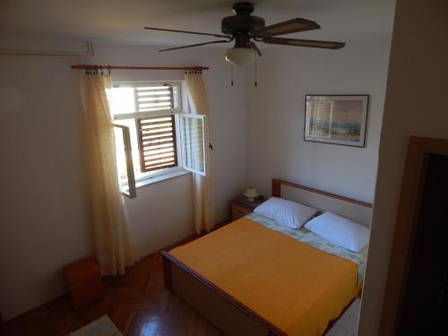 sypialnia z łóżkiem i wentylatorem sufitowym w obiekcie Rooms with a parking space Stari Grad, Hvar - 14831 w mieście Stari Grad