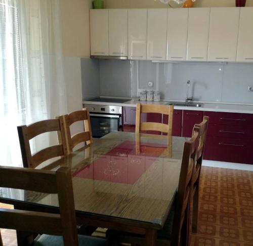 a kitchen with a wooden table and chairs and a kitchen with white cabinets at Apartments with WiFi Omis - 14843 in Omiš
