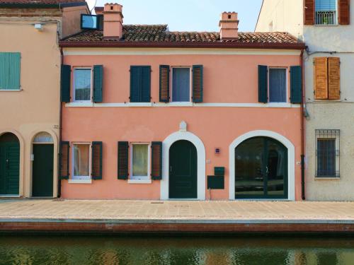 a building next to the water in a canal at B&B La Pitagora in Comacchio