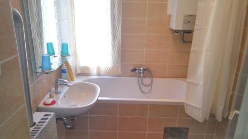 a bathroom with a sink and a bath tub with a window at Apartments with a parking space Zagreb - 14890 in Zagreb