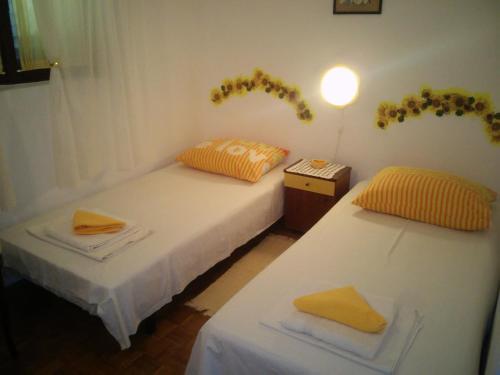 twee bedden in een kamer met gele handdoeken erop bij Apartments and rooms with parking space Stari Grad, Hvar - 14888 in Stari Grad