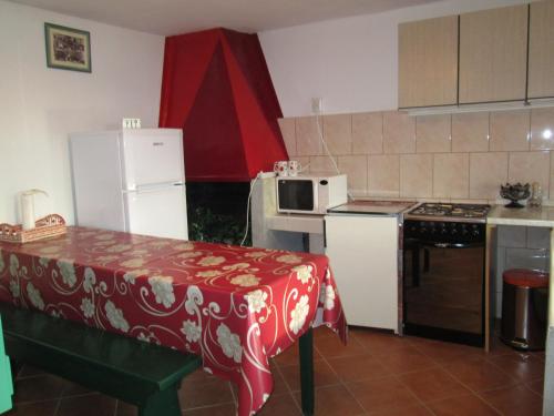 a kitchen with a table and a white refrigerator at Seaside holiday house Cove Bristva, Korcula - 14892 in Prizba