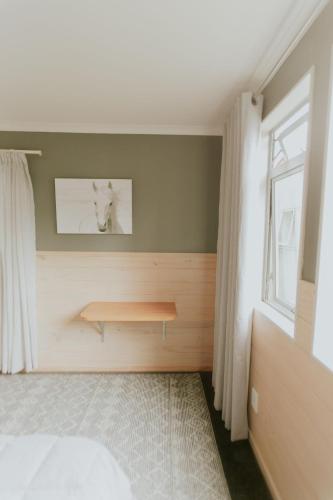 a bedroom with a wooden bench next to a window at Waitomo Village Chalets home of Kiwipaka in Waitomo Caves