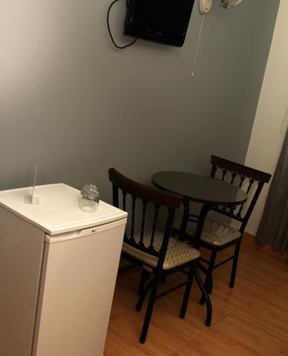 ein kleiner Tisch und Stühle in einer Küche mit einem Fernseher in der Unterkunft Hotel Vanetom in Chiclayo