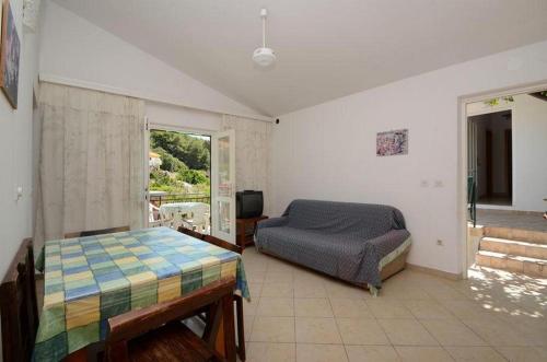 a bedroom with a bed and a tv in it at Apartments by the sea Prizba, Korcula - 14940 in Prizba