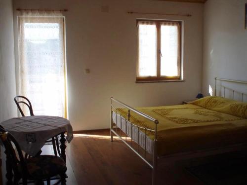 um quarto com uma cama, uma mesa e uma janela em Apartments with a parking space Mali Losinj (Losinj) - 14944 em Mali Lošinj