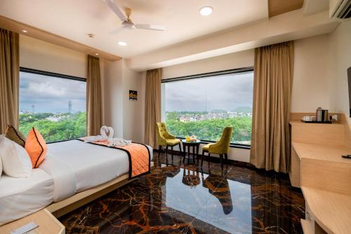 um quarto de hotel com uma cama e uma grande janela em Enrise by Sayaji Aurangabad em Aurangabad