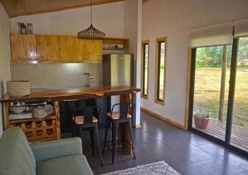 a kitchen with a counter and chairs in a room at Taina Ta in Hanga Roa