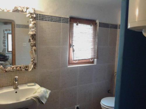 a bathroom with a sink and a toilet and a mirror at Apartments with a parking space Porozina, Cres - 14980 in Filozići