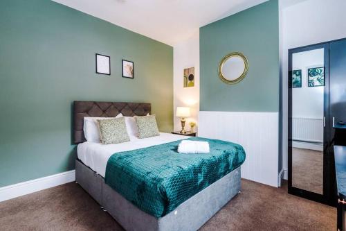 a bedroom with a large bed with a green blanket at Charming 3 Bed Home in the Garden Quarter, Chester in Chester