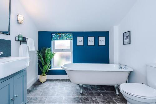 uma casa de banho azul e branca com uma banheira e um WC em Charming 3 Bed Home in the Garden Quarter, Chester em Chester