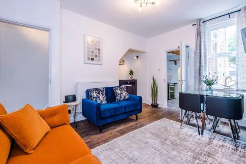 a living room with a blue couch and a table at Charming 3 Bed Home in the Garden Quarter, Chester in Chester