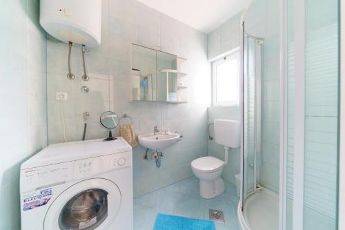 y baño con lavadora y lavamanos. en Apartments by the sea Preko, Ugljan - 14985, en Preko