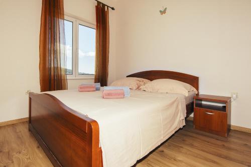 a bedroom with two beds and a window at Apartments by the sea Preko, Ugljan - 14985 in Preko