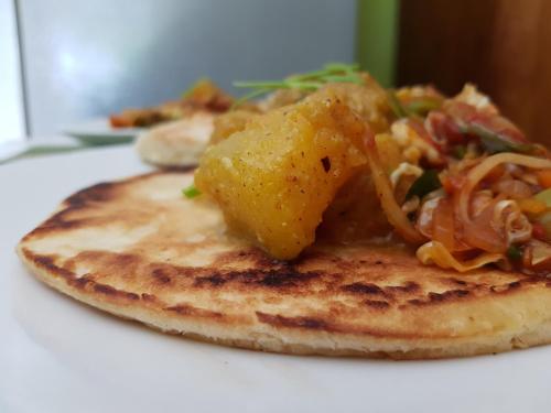 a plate of food with pancakes and vegetables on it at Plantation Surf Inn & Restaurant - Midigama in Midigama