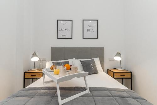 un letto bianco con un vassoio di frutta sopra di Córdoba Suites Apartments a Cordoba