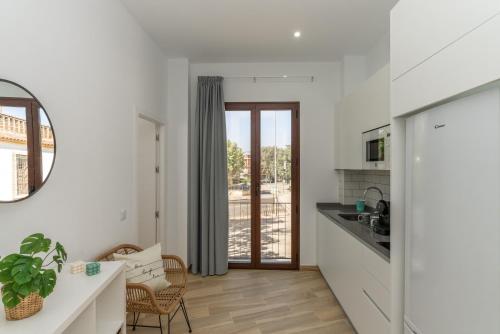 eine Küche mit weißen Wänden und einem Tisch und Stühlen in der Unterkunft Córdoba Suites Apartments in Córdoba