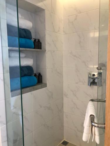 a bathroom with a shower with towels and a glass door at The Aristo-2-903 in Ban Lum Fuang