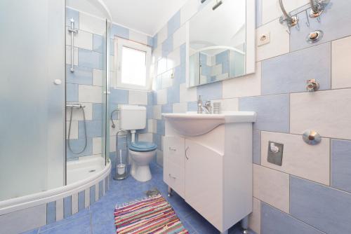 La salle de bains est pourvue d'un lavabo, de toilettes et d'une douche. dans l'établissement Apartments with a parking space Poljana, Ugljan - 15019, à Poljana