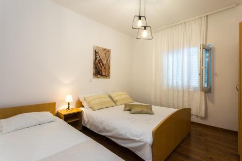 En eller flere senge i et værelse på Family friendly apartments with a swimming pool Podstrana, Split - 15040
