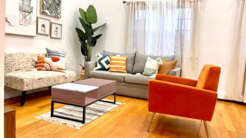 a living room with a couch and a chair at Modern apartment with parking & quick ride to Manhattan in Cedar Manor