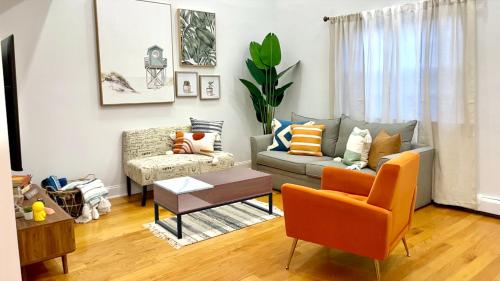 a living room with a couch and a chair at Modern apartment with parking & quick ride to Manhattan in Cedar Manor