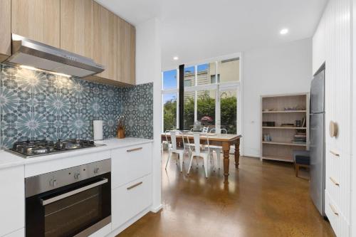 a kitchen with a stove and a dining room at Terrace Lofts Apartments in Ocean Grove