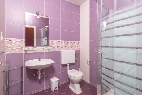 a purple bathroom with a toilet and a sink at Apartments by the sea Cove Pribinja, Hvar - 15083 in Hvar