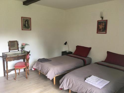 Cette chambre comprend deux lits et un bureau avec un piano. dans l'établissement Le Clos Crista Galli, à Saint-Junien