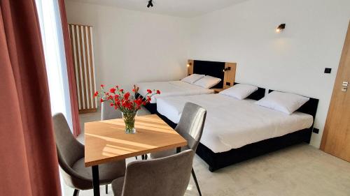 una habitación de hotel con 2 camas y una mesa con flores en Bursztynowa Rosa, en Łeba
