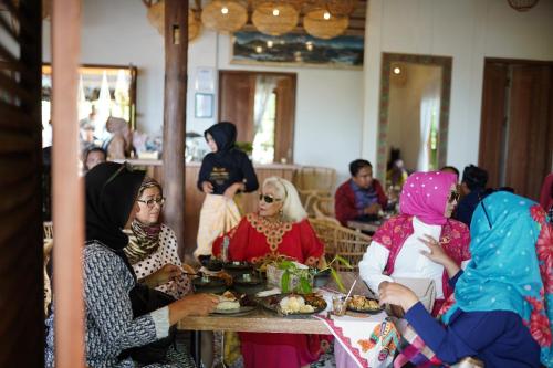 a group of people sitting around a table eating food at Casa Nemo Beach Resort & Spa in Sabong