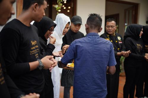 a group of people standing around a man holding a plate of food at Casa Nemo Beach Resort & Spa in Sabong