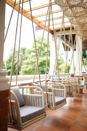 a room with wicker chairs and a large window at Casa Nemo Beach Resort & Spa in Sabong