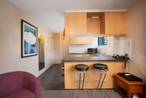 a kitchen with a counter and two bar stools at Drummoyne Furnished Apartments in Sydney