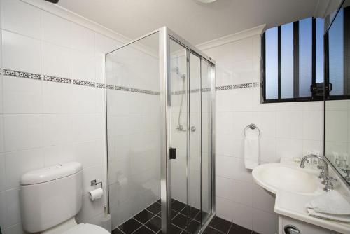 a bathroom with a shower and a toilet and a sink at Drummoyne Furnished Apartments in Sydney