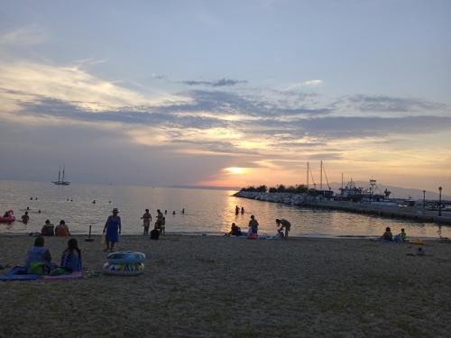 a group of people on a beach at sunset at ANGELS HOUSE in Skala Kallirakhis