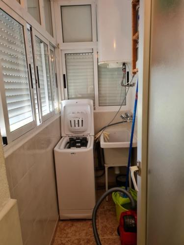 a small bathroom with a sink and a washing machine at apartamento Gandiazar 4 playa, VT-52979-V in Playa de Gandia