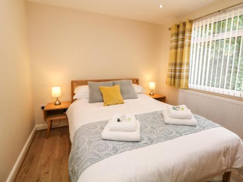 a bedroom with a bed with two towels on it at Cedar Holme in Chesterfield