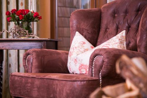 a brown chair with two pillows on it at Rosa Canina Superior in Sankt Anton am Arlberg