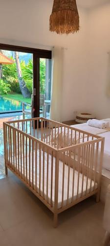 a bedroom with a bed and a view of a pool at Villa Uhaïna Amed Bali in Amed