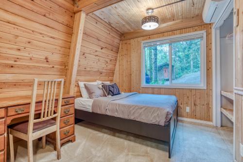 um quarto com uma cama, uma secretária e uma janela em The Emerald Slope em Welches