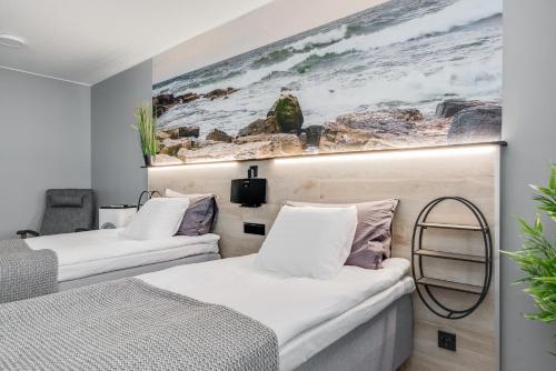dwa łóżka w pokoju z obrazem na ścianie w obiekcie Majoituspalvelu Nurmi Oy City Apartment Kauppakatu 52 w mieście Raahe