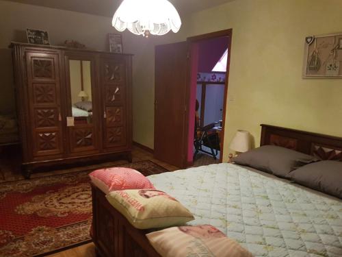 a bedroom with a bed and a chandelier at Horizon Aubrac Laguiole in Laguiole