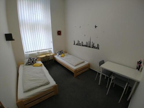 Habitación con 2 camas, mesa y escritorio. en ApartHostel Brno, en Brno