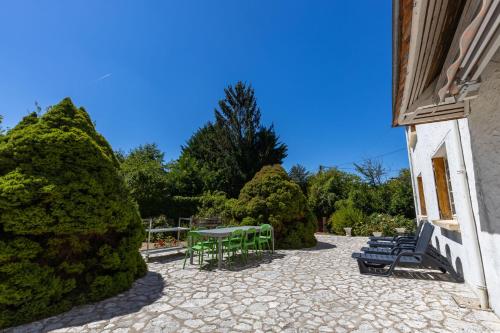 a patio with a table and chairs and trees at Le Gite du Chevreuil, 200 Mètres de BEAUVAL in Saint-Aignan