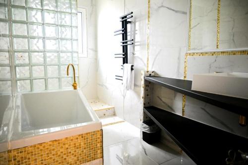 ein Badezimmer mit einer Badewanne und einem Waschbecken in der Unterkunft Résidence Le Lenn-louannec - Maisons & Villas pour 6 Personnes 784 in Lannion