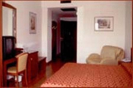 a living room with a bed and a television at Hotel Corone in Caerano di San Marco