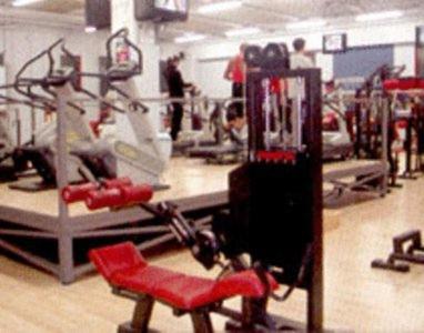 a gym with a red chair and machines at Hotel Corone in Caerano di San Marco