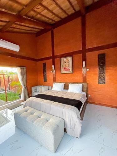a large bedroom with a large bed and a couch at Ginza Bungalow Yogyakarta in Demangan